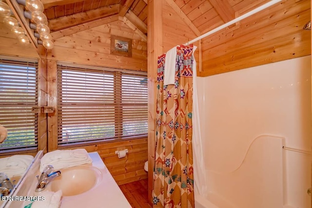 bathroom featuring curtained shower, wooden walls, lofted ceiling with beams, vanity, and wood ceiling