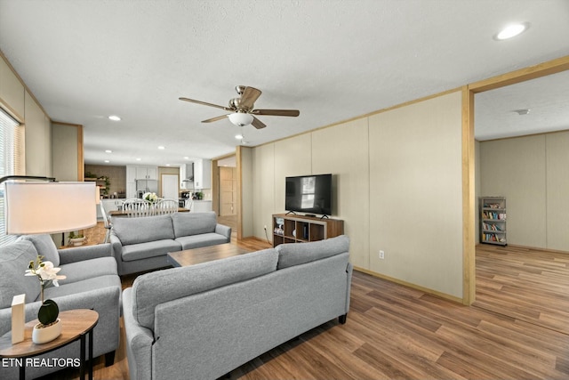 living room with ceiling fan and light wood-type flooring