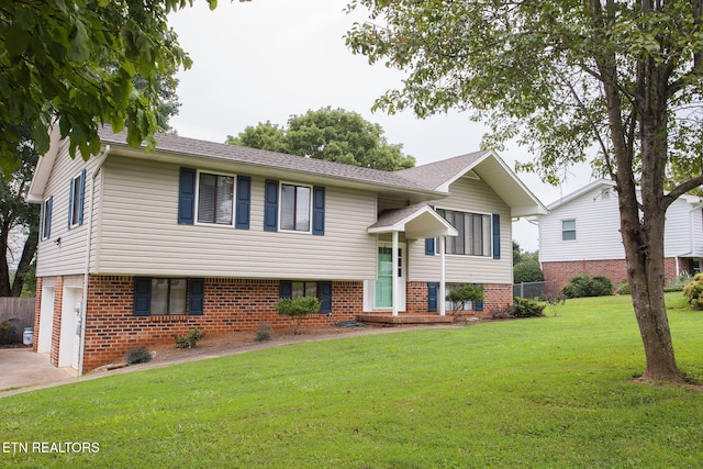 split foyer home with a garage and a front yard