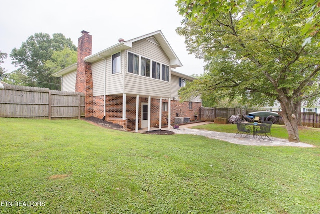 rear view of property with a patio and a lawn