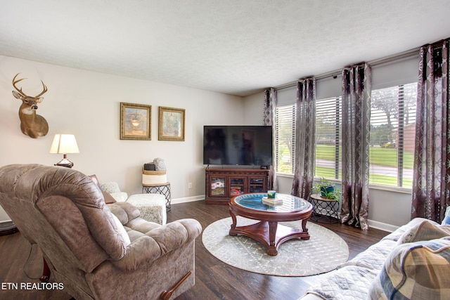 living room featuring dark wood-type flooring and a textured ceiling