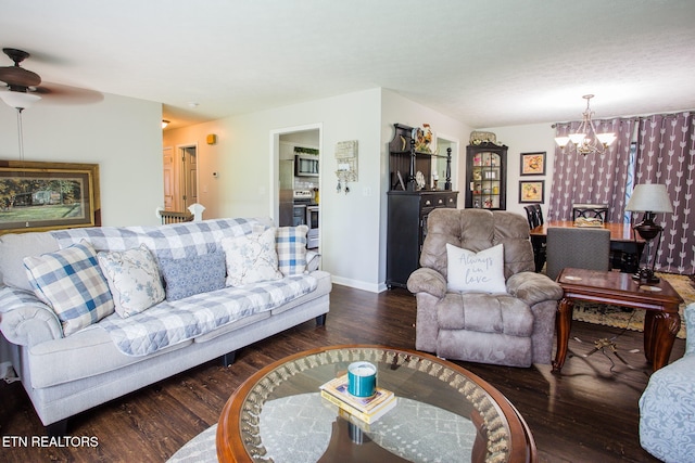 living room featuring dark hardwood / wood-style floors and ceiling fan with notable chandelier