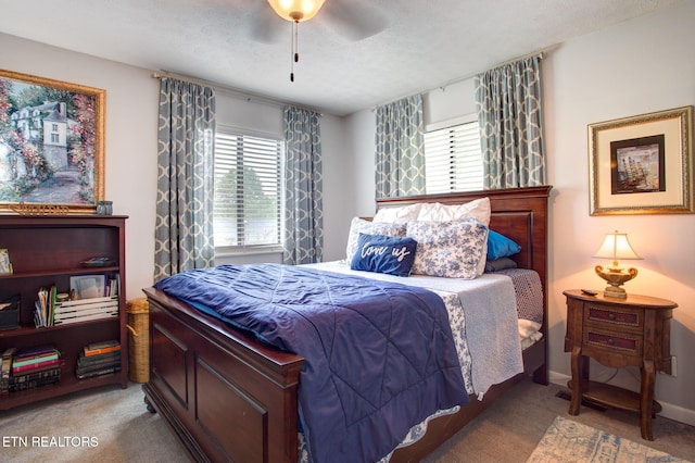 bedroom with multiple windows, light colored carpet, and a textured ceiling