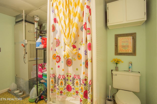 bathroom featuring toilet, a shower with shower curtain, heating unit, and a drop ceiling