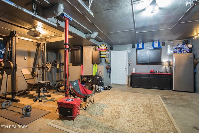 garage featuring a garage door opener and stainless steel refrigerator