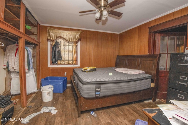 bedroom with crown molding, dark wood-type flooring, and wood walls