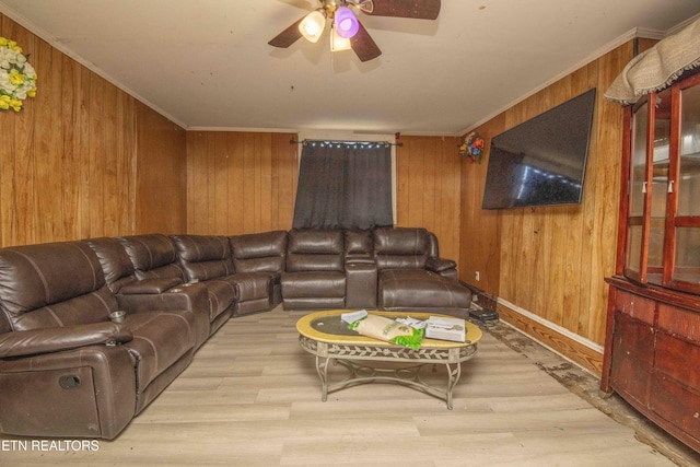 living room with crown molding, wooden walls, and light wood-type flooring