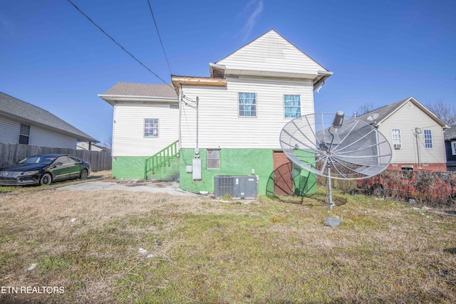 back of house with cooling unit and a yard