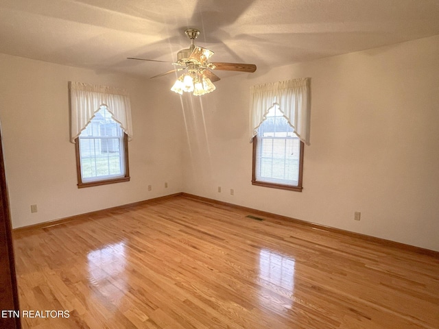 unfurnished room featuring ceiling fan, a healthy amount of sunlight, and light wood-type flooring