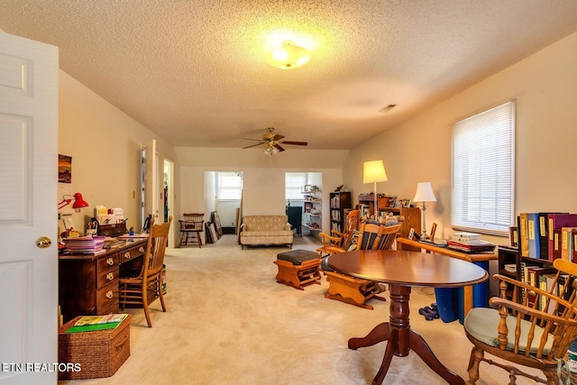 carpeted dining space with a textured ceiling and ceiling fan