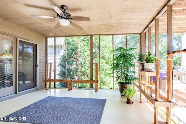 unfurnished sunroom featuring a wealth of natural light and ceiling fan