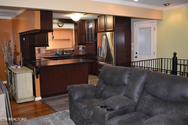 kitchen featuring stainless steel refrigerator with ice dispenser, crown molding, hardwood / wood-style floors, and dark brown cabinets