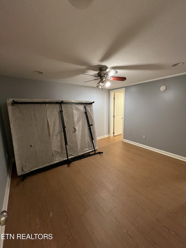 interior space featuring wood-type flooring, ceiling fan, and a textured ceiling