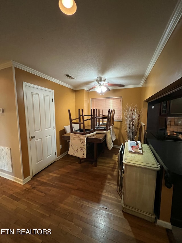 dining room featuring dark wood-type flooring, ceiling fan, and ornamental molding