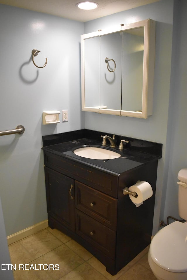 bathroom with vanity, tile patterned floors, and toilet