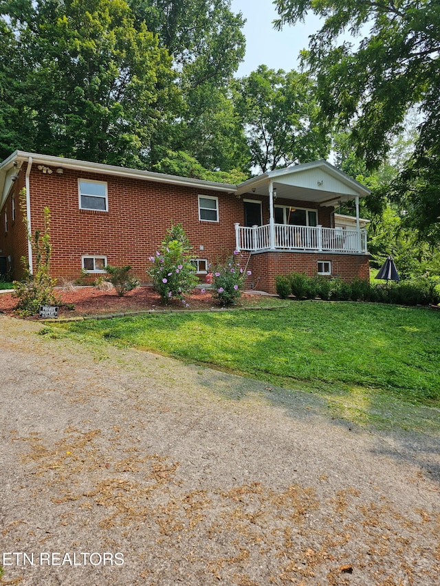 view of front of house featuring a front yard, central air condition unit, and a porch