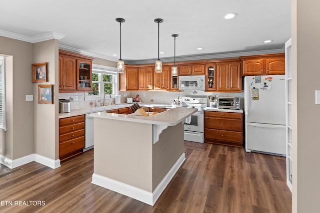 kitchen featuring crown molding, white appliances, dark wood-type flooring, a kitchen island, and decorative backsplash