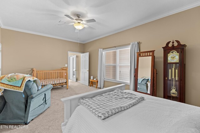 carpeted bedroom with ornamental molding and ceiling fan