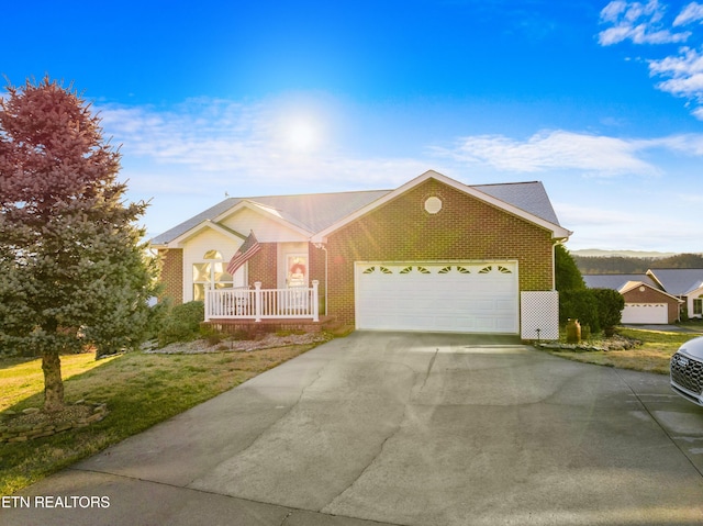 ranch-style house featuring a garage, covered porch, and a front lawn