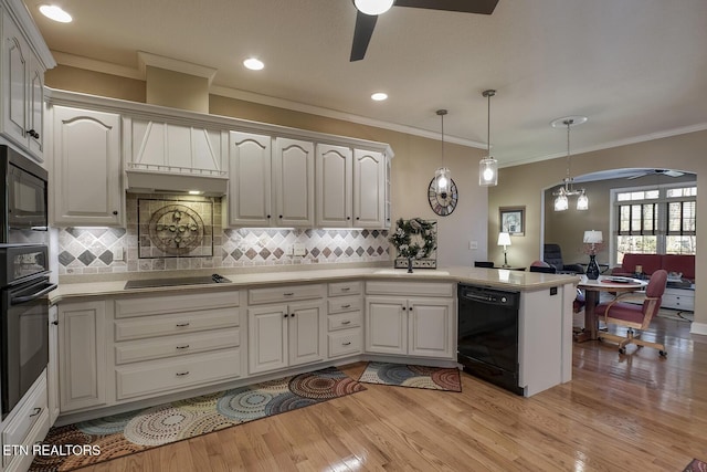 kitchen with black appliances, a ceiling fan, a peninsula, ornamental molding, and light wood finished floors
