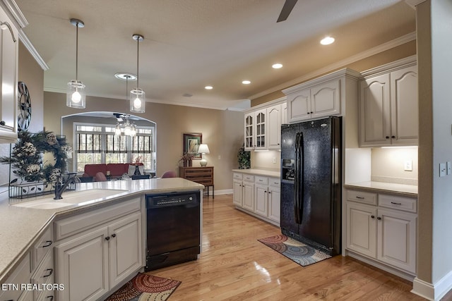 kitchen with black appliances, ornamental molding, a peninsula, a sink, and ceiling fan