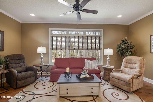 living room featuring wood finished floors, a ceiling fan, crown molding, baseboards, and recessed lighting