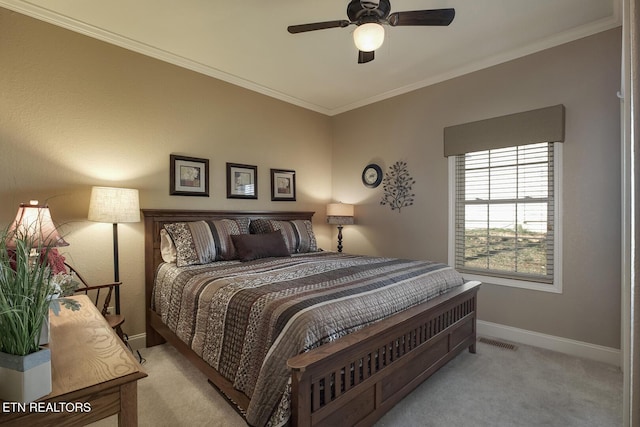 carpeted bedroom featuring ornamental molding, baseboards, and a ceiling fan