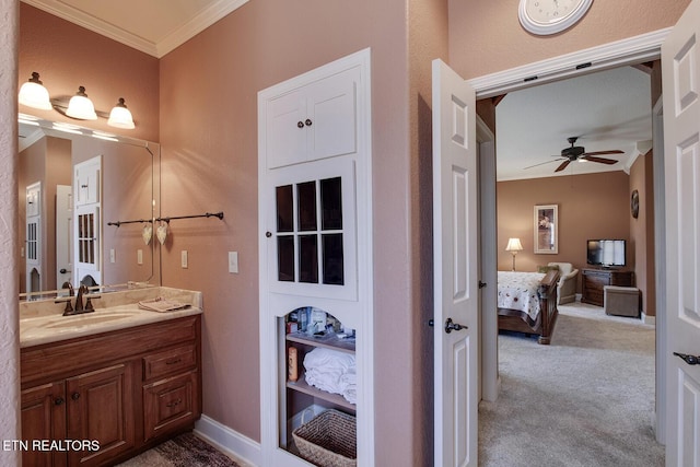 ensuite bathroom featuring crown molding, ceiling fan, and vanity