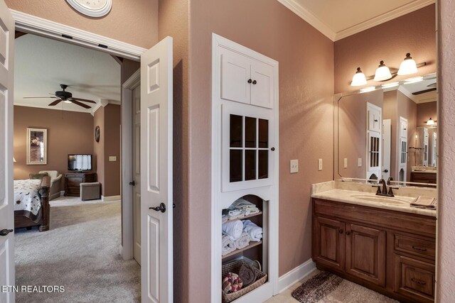 bathroom featuring ornamental molding, ceiling fan, vanity, connected bathroom, and baseboards