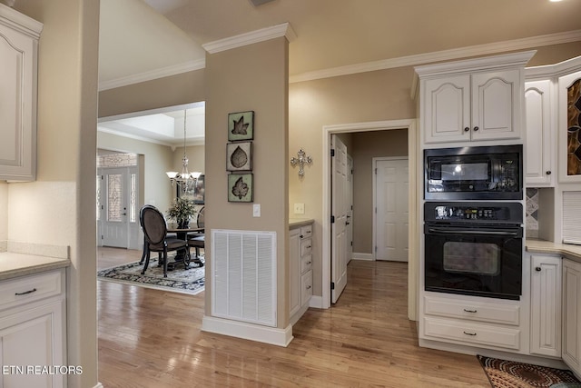kitchen with black appliances, a chandelier, light wood finished floors, crown molding, and baseboards