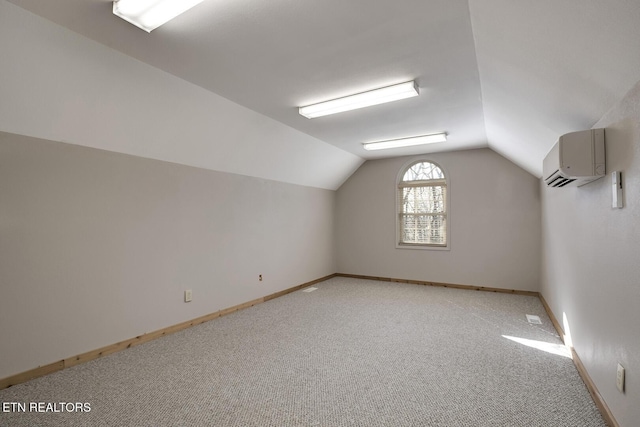 additional living space featuring light carpet, lofted ceiling, baseboards, and a wall mounted AC