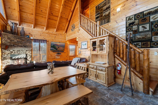 dining space with high vaulted ceiling, beam ceiling, wooden ceiling, and wood walls