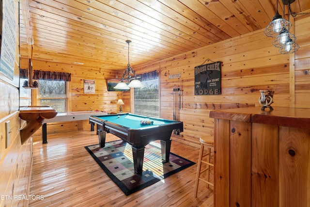 playroom with pool table, light hardwood / wood-style flooring, wooden ceiling, and wooden walls