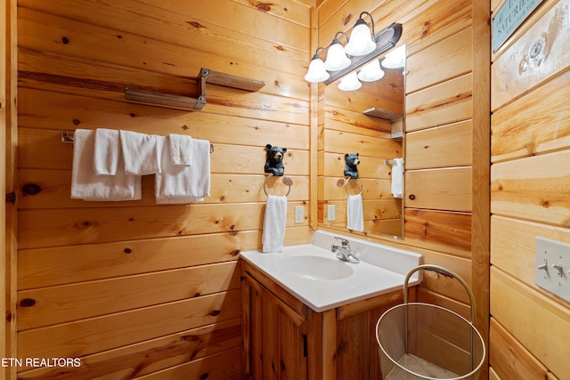 bathroom with vanity and wood walls