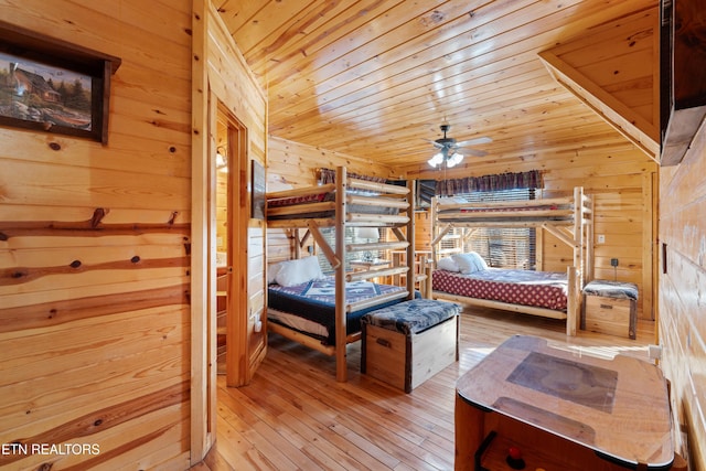 bedroom with wood ceiling, wooden walls, and hardwood / wood-style flooring