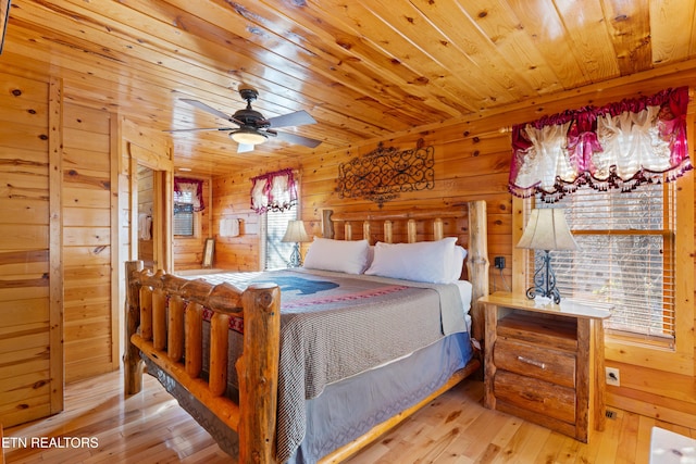 bedroom with wood ceiling, wooden walls, and light hardwood / wood-style floors