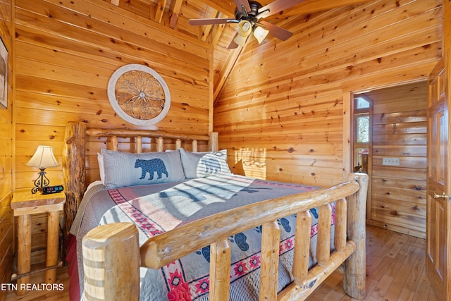 bedroom featuring wood-type flooring, lofted ceiling, and wooden walls