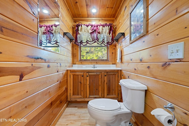 bathroom featuring wooden walls, hardwood / wood-style flooring, vanity, wood ceiling, and toilet