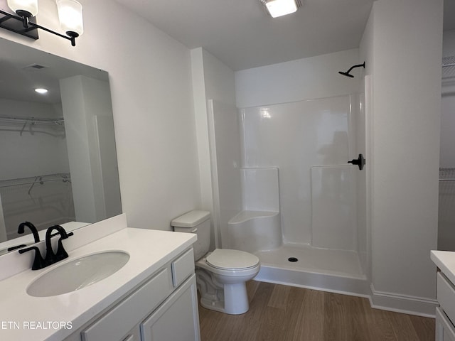 bathroom featuring hardwood / wood-style flooring, vanity, and a shower