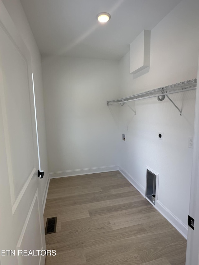 laundry area with hookup for an electric dryer and light hardwood / wood-style floors