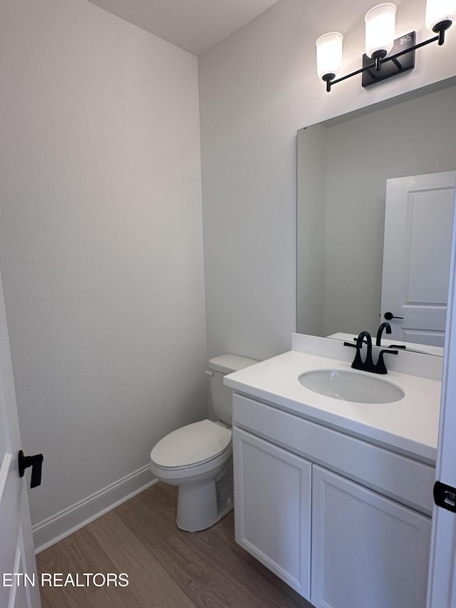 bathroom featuring vanity, hardwood / wood-style floors, and toilet