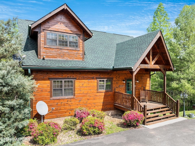 log-style house with covered porch