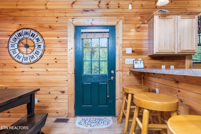 entrance foyer featuring wooden walls and light wood-type flooring