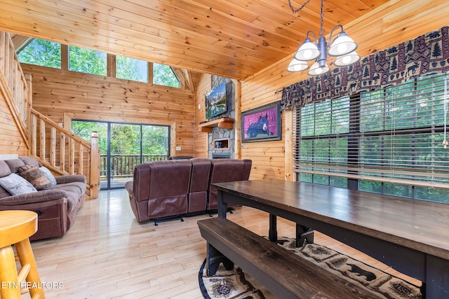 dining area featuring high vaulted ceiling, wooden walls, wood ceiling, light hardwood / wood-style floors, and an inviting chandelier