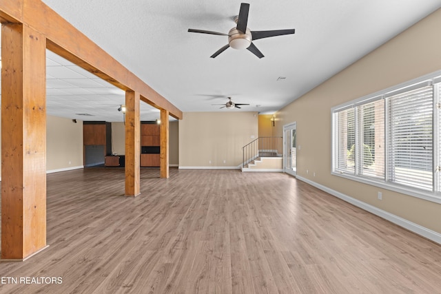 unfurnished living room featuring wood-type flooring and ceiling fan