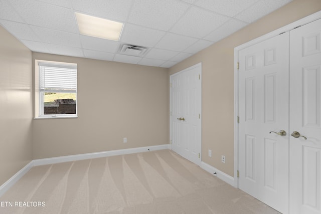 carpeted empty room featuring a paneled ceiling