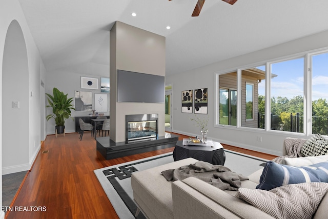 living room with lofted ceiling, dark hardwood / wood-style floors, and ceiling fan