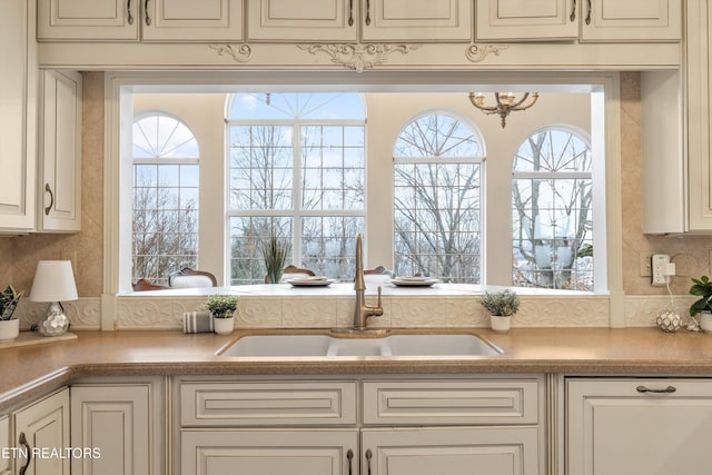 kitchen with light countertops, cream cabinets, and a sink