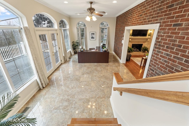 unfurnished office featuring french doors, marble finish floor, ornamental molding, a large fireplace, and brick wall