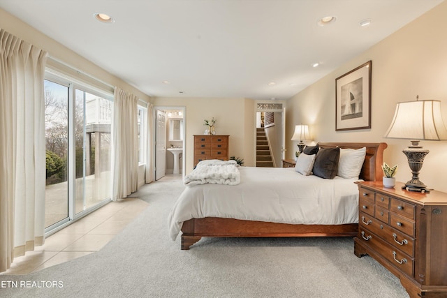 bedroom featuring light tile patterned floors, recessed lighting, light colored carpet, access to exterior, and ensuite bath